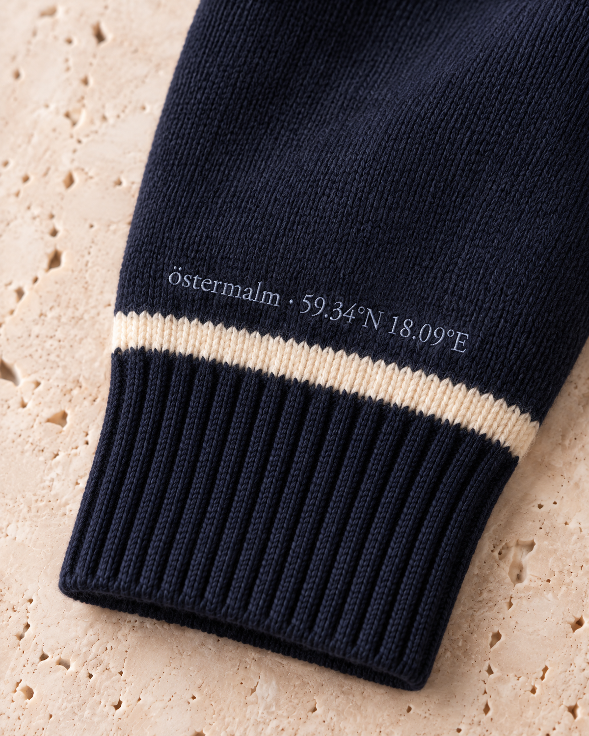 the merino quarter-zip in navy · östermalm — cuff embroidery detail