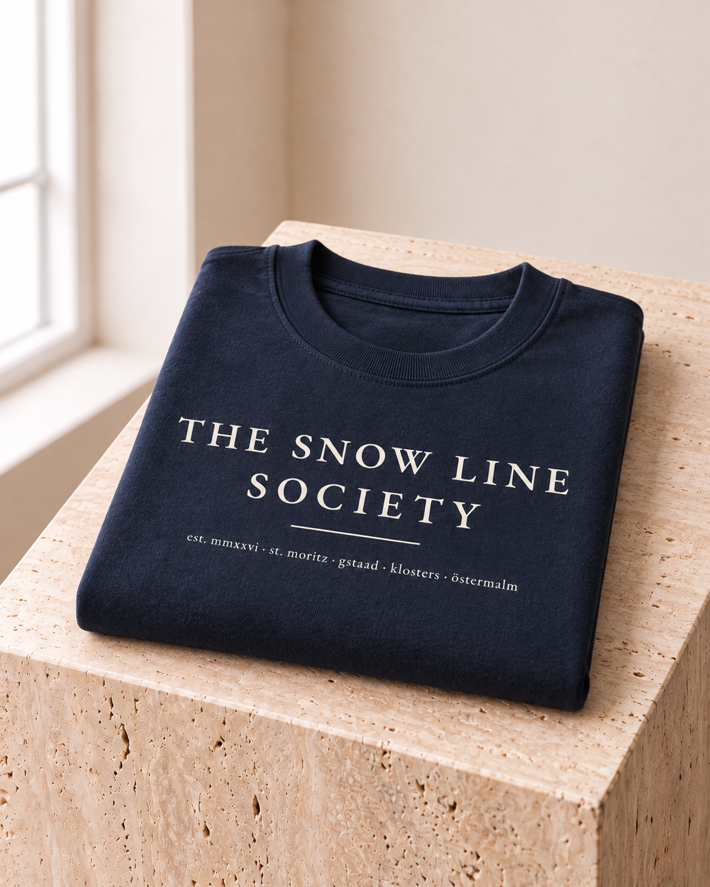 the snow line society tee in navy — folded on travertine