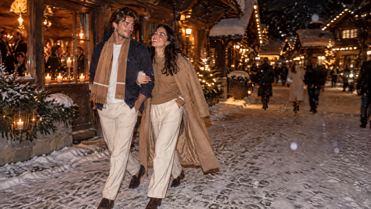gstaad after dark: a couple on the snowy promenade in the canvas overshirt, camel scarf and camel crewneck